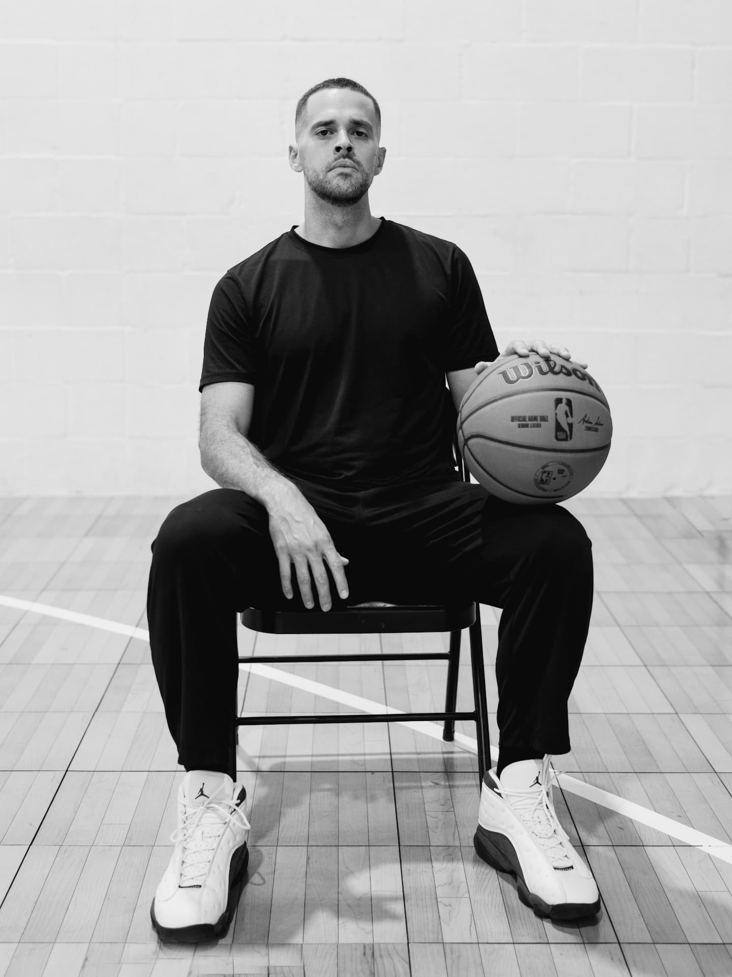 Coach Carlos seated with a basketball